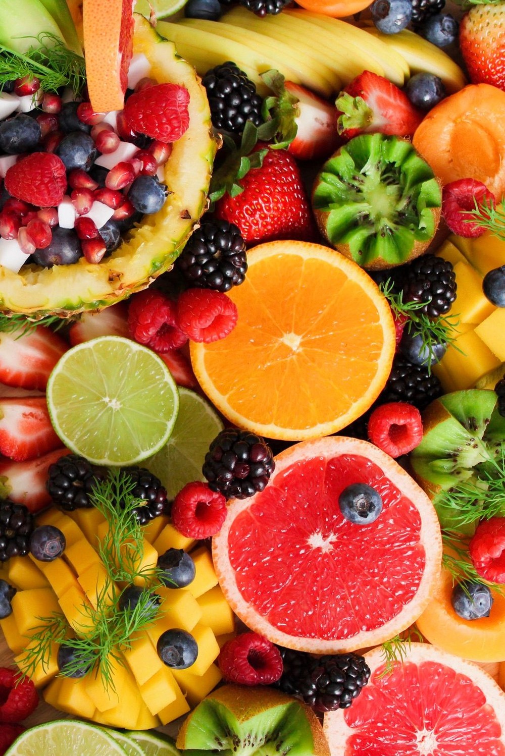 Composizione colorata di frutta fresca: fragole, arance, kiwi, more e mango